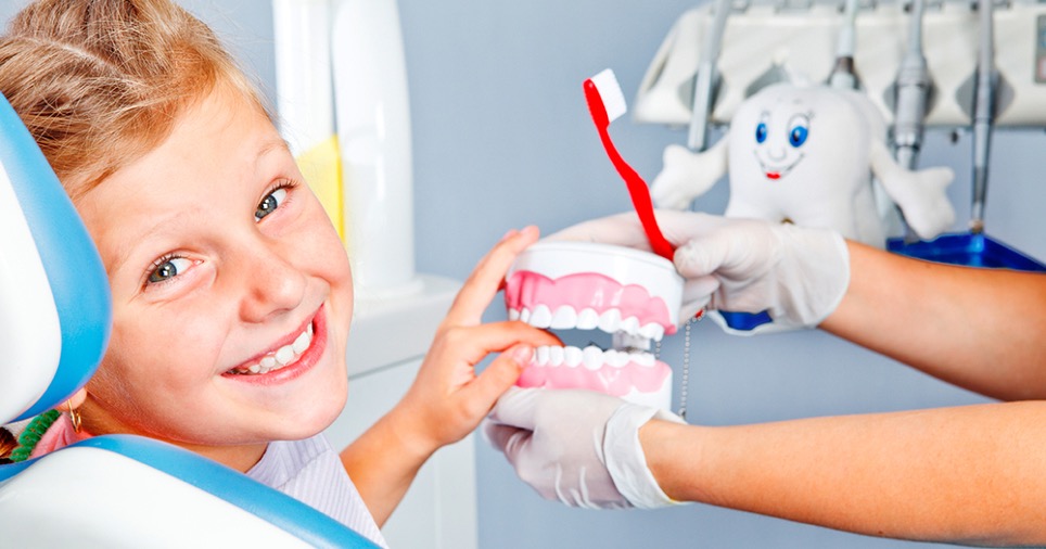 bambino sorridente sulla poltrona del dentista