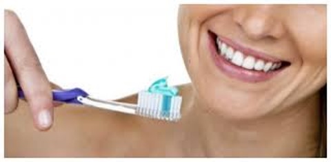 donna che sorride con spazzolino da denti in mano